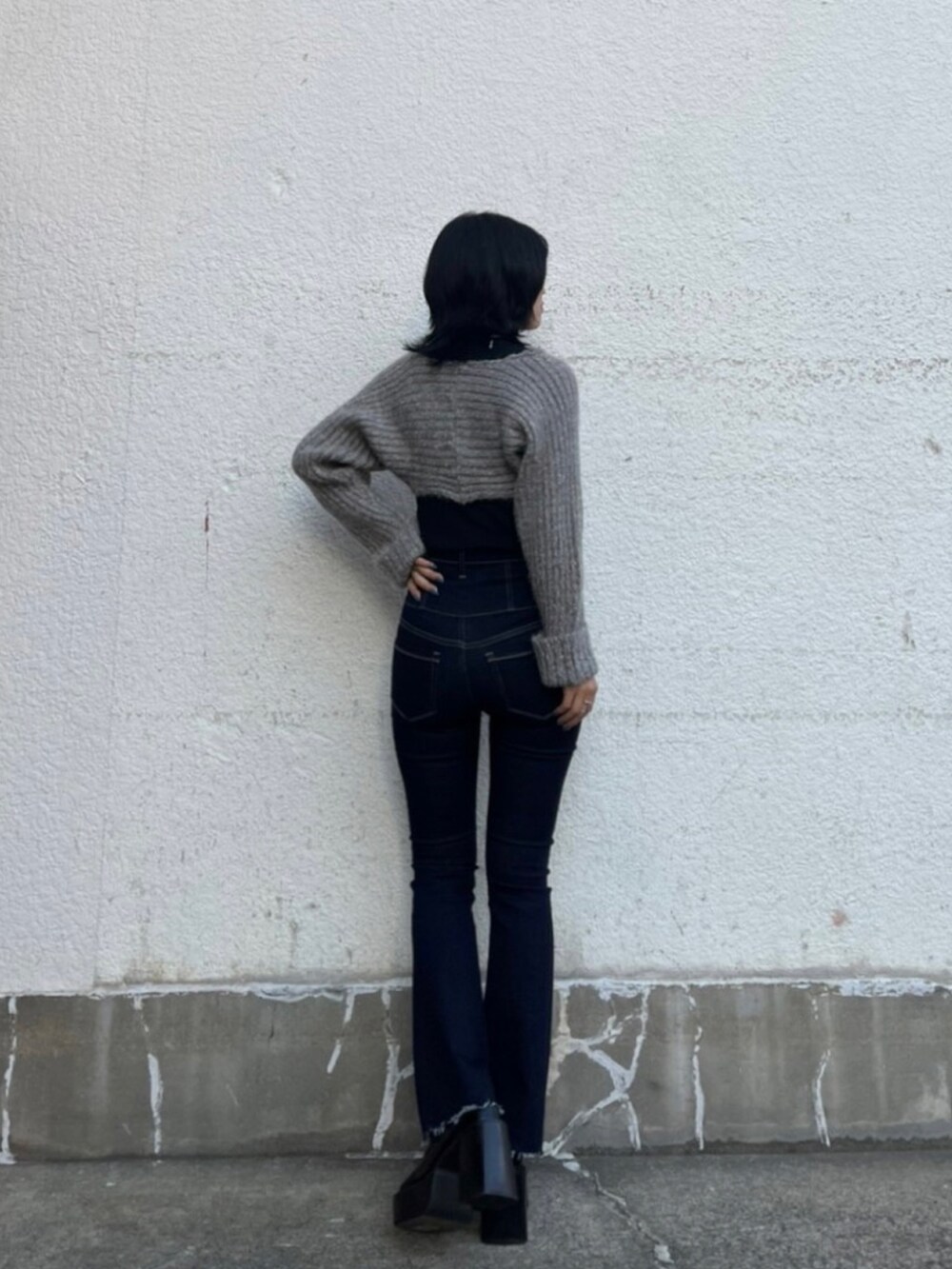ブラック系のニット/セーター、ブルー系のデニムパンツ、ブラック系のローファーを着用したレディースの秋コーディネートの3枚目の写真