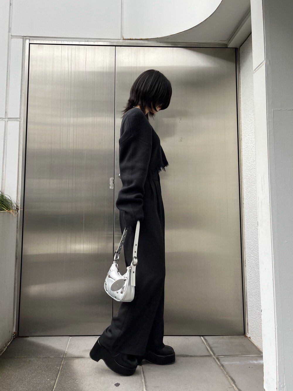 ブラック系のニット/セーター、ブラック系のブーツ、ブラック系のその他パンツを着用したレディースの冬コーディネートの2枚目の写真