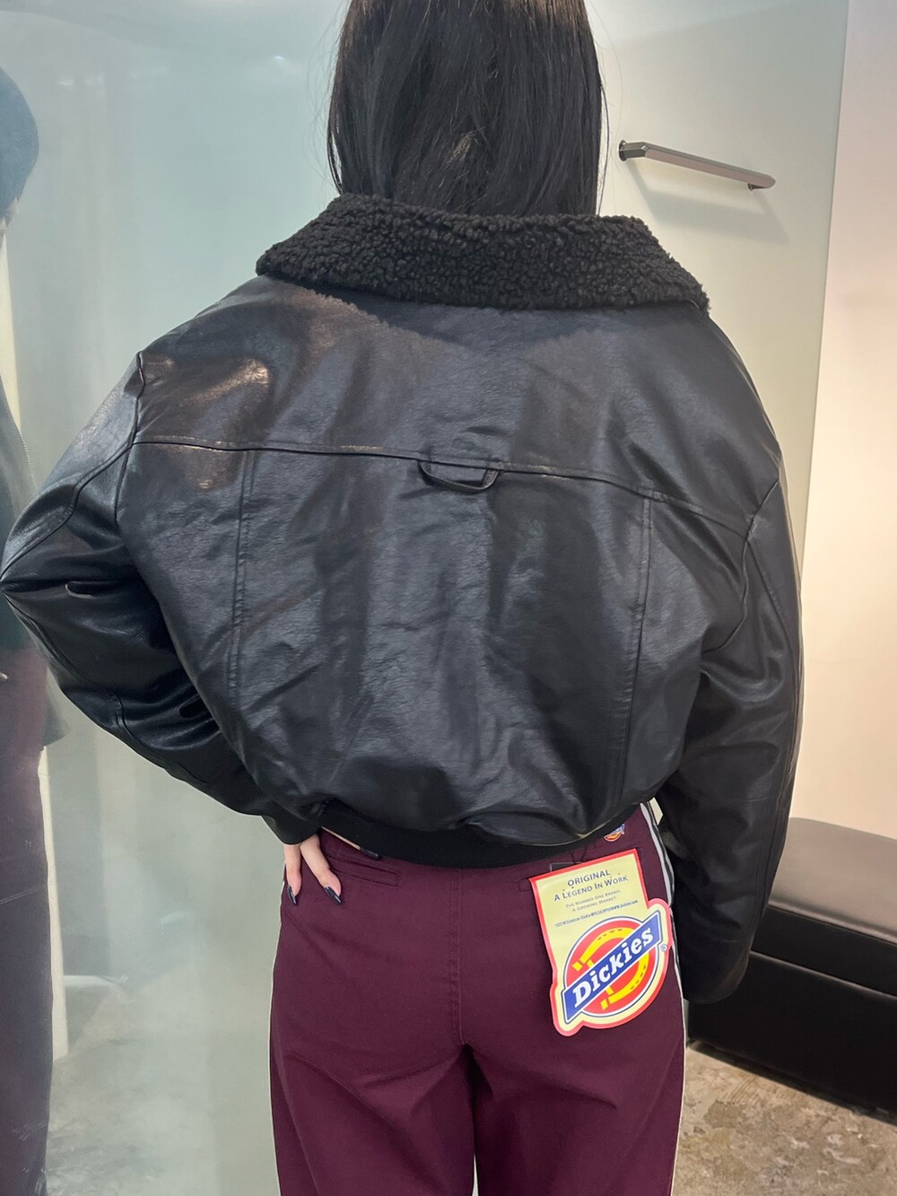 ブラック系のブルゾン、レッド系のその他パンツ、ブラック系のニット/セーターを着用したレディースの秋コーディネートの5枚目の写真