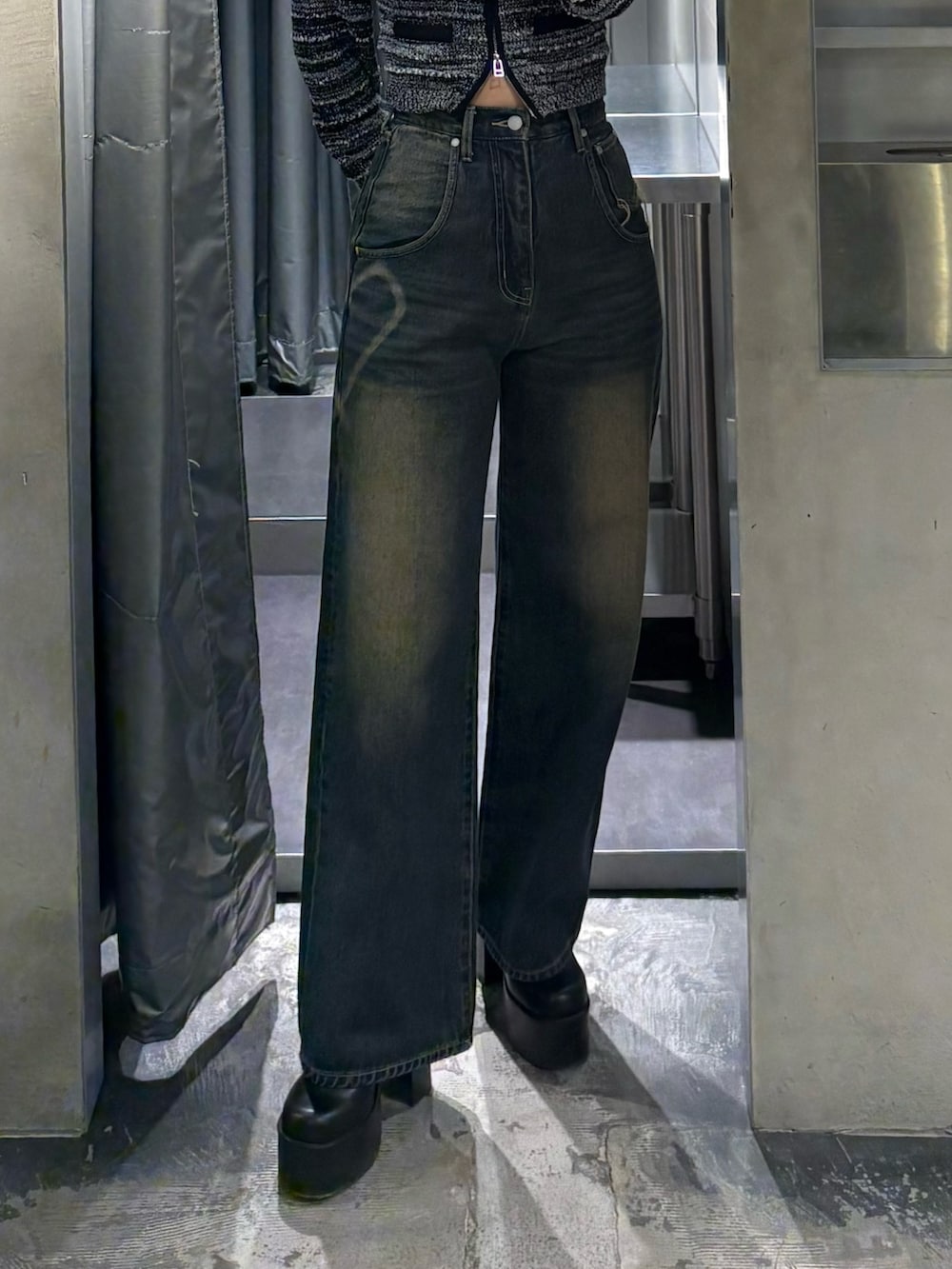 ブラック系のニット/セーター、ブルー系のデニムパンツ、ブラック系のブーツを着用したレディースの冬コーディネートの5枚目の写真