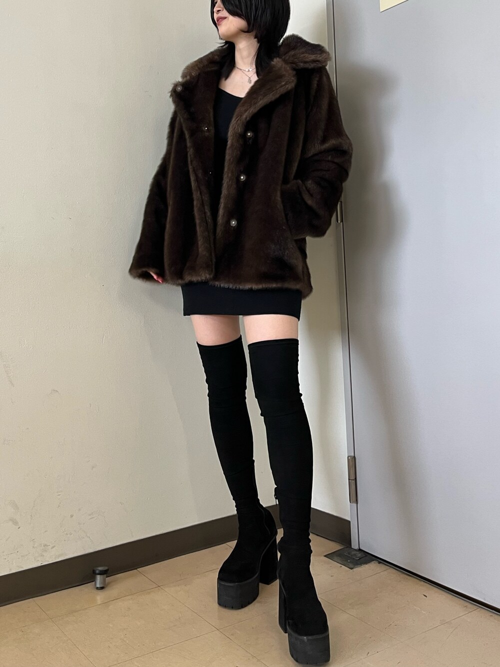 ブラウン系のその他アウター、ブラック系のワンピース、ブラック系のブーツを着用したレディースの冬コーディネートの3枚目の写真