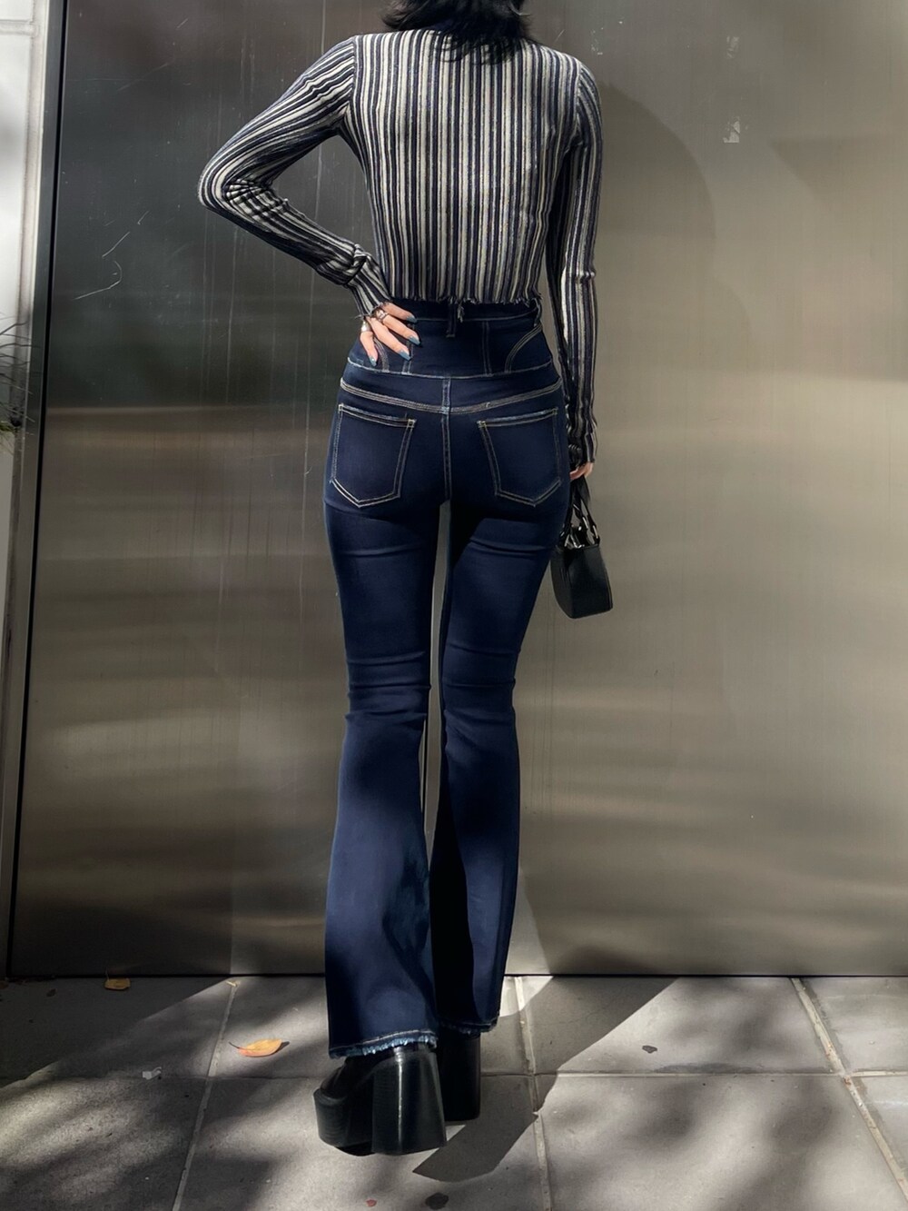 ブラック系のチェスターコート、その他のニット/セーター、ブルー系のデニムパンツを着用したレディースの冬コーディネートの7枚目の写真