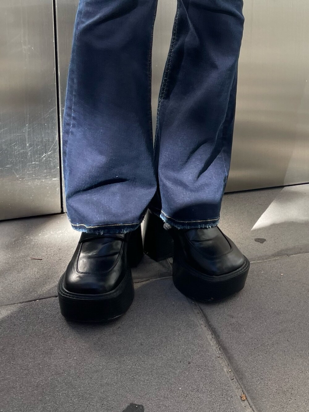 ブラック系のチェスターコート、その他のニット/セーター、ブルー系のデニムパンツを着用したレディースの冬コーディネートの8枚目の写真