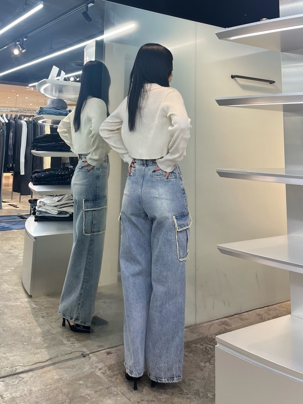 ホワイト系のニット/セーター、ブルー系のデニムパンツ、ブラック系のパンプスを着用したレディースの春コーディネートの4枚目の写真