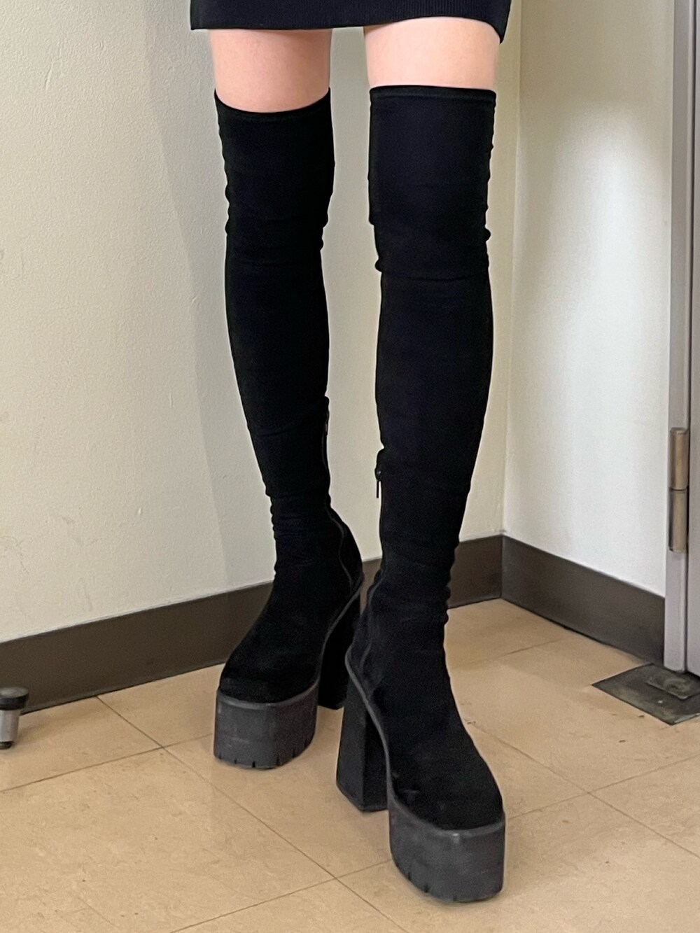 ブラウン系のその他アウター、ブラック系のワンピース、ブラック系のブーツを着用したレディースの冬コーディネートの7枚目の写真