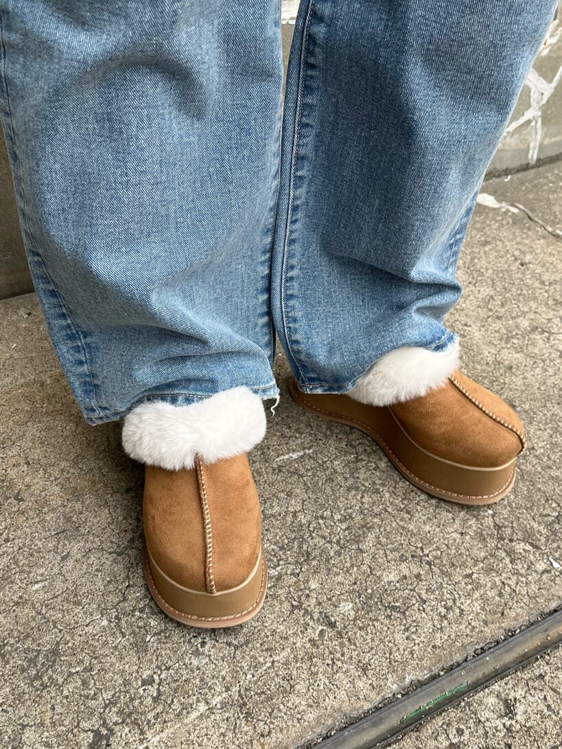 ブルー系のデニムパンツ、ベージュ系のスリッポン、ブラック系のベストを着用したレディースの秋コーディネートの8枚目の写真