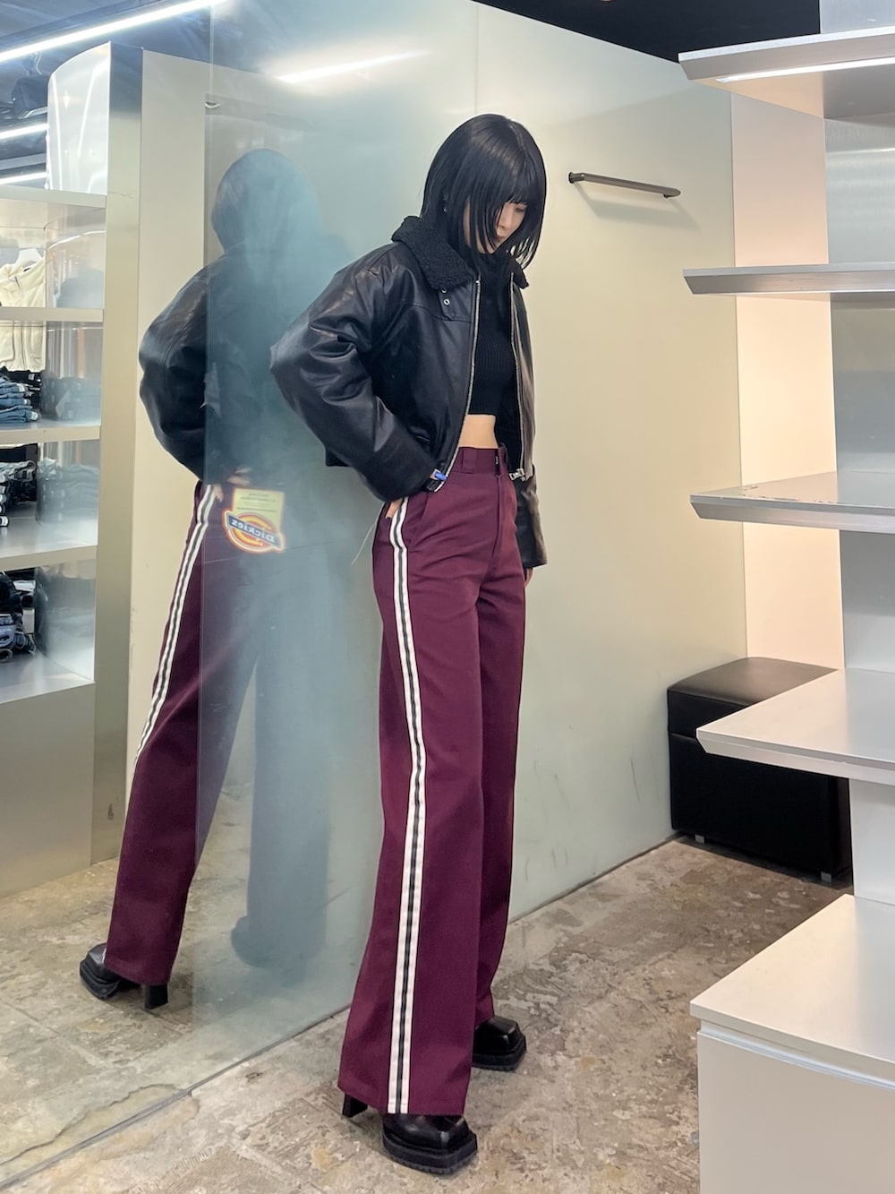 ブラック系のブルゾン、レッド系のその他パンツ、ブラック系のニット/セーターを着用したレディースの秋コーディネートの2枚目の写真