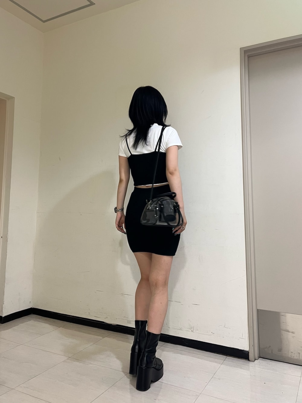 ホワイト系のTシャツ/カットソー、ブラック系のキャミソール、ブラック系のスカートを着用したレディースの春コーディネートの3枚目の写真