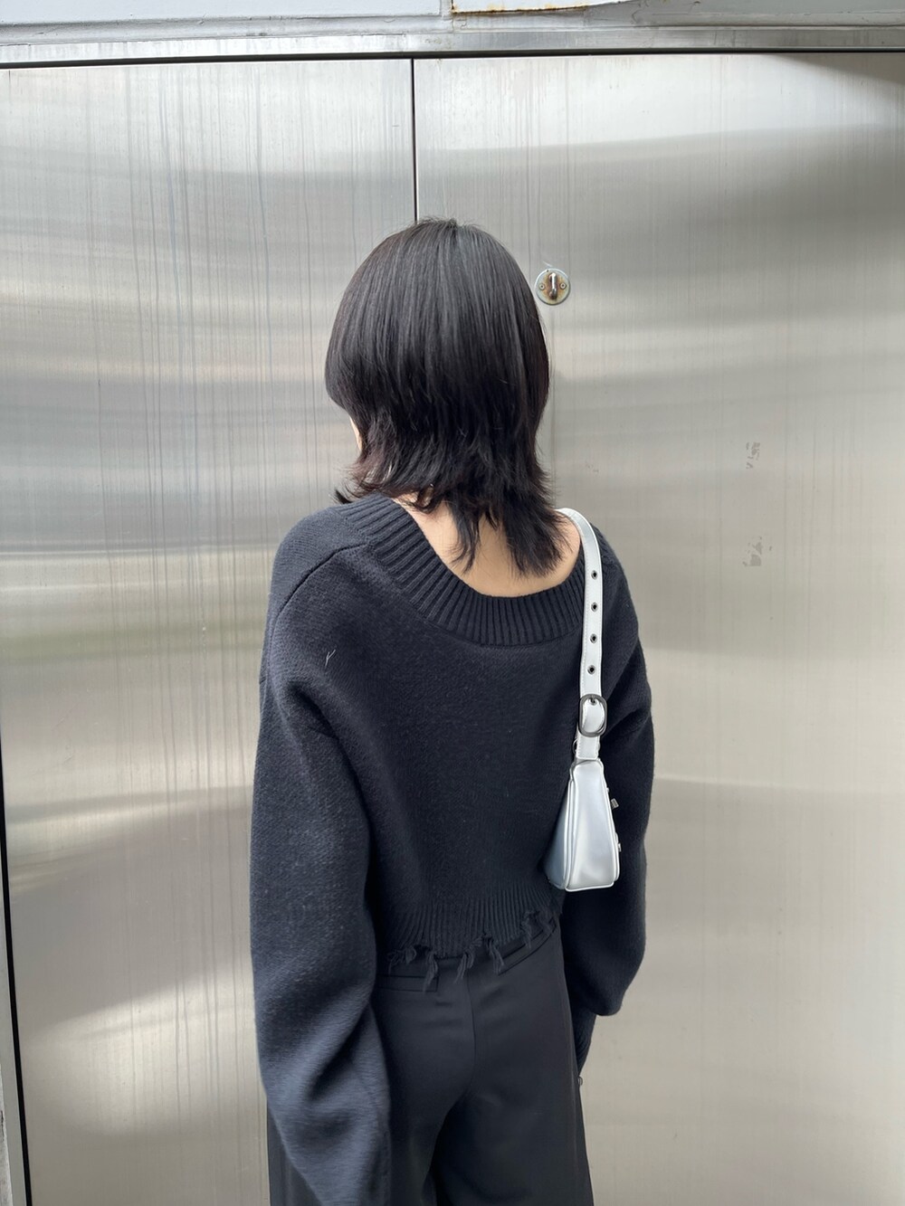 ブラック系のニット/セーター、ブラック系のブーツ、ブラック系のその他パンツを着用したレディースの冬コーディネートの6枚目の写真