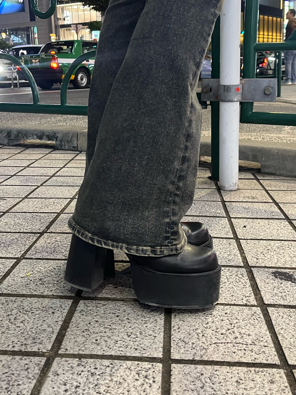 ブラック系のニット/セーター、ブルー系のデニムパンツ、ブラック系のブーツを着用したレディースの秋コーディネートの7枚目の写真
