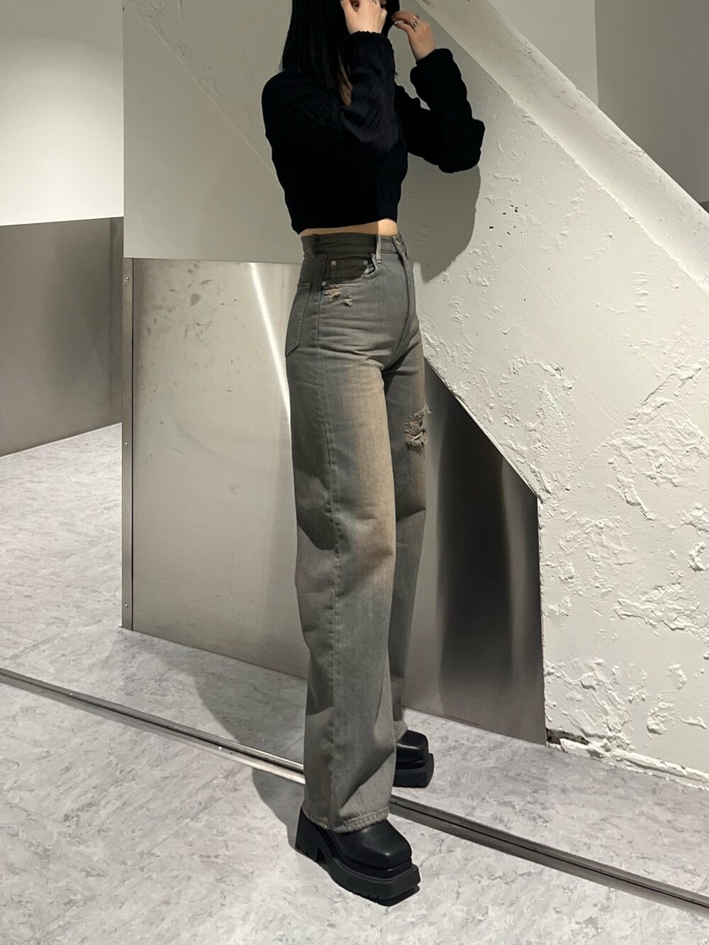 ブラック系のニット/セーター、グレー系のデニムパンツ、ブラック系のブーツを着用したレディースの冬コーディネートの3枚目の写真