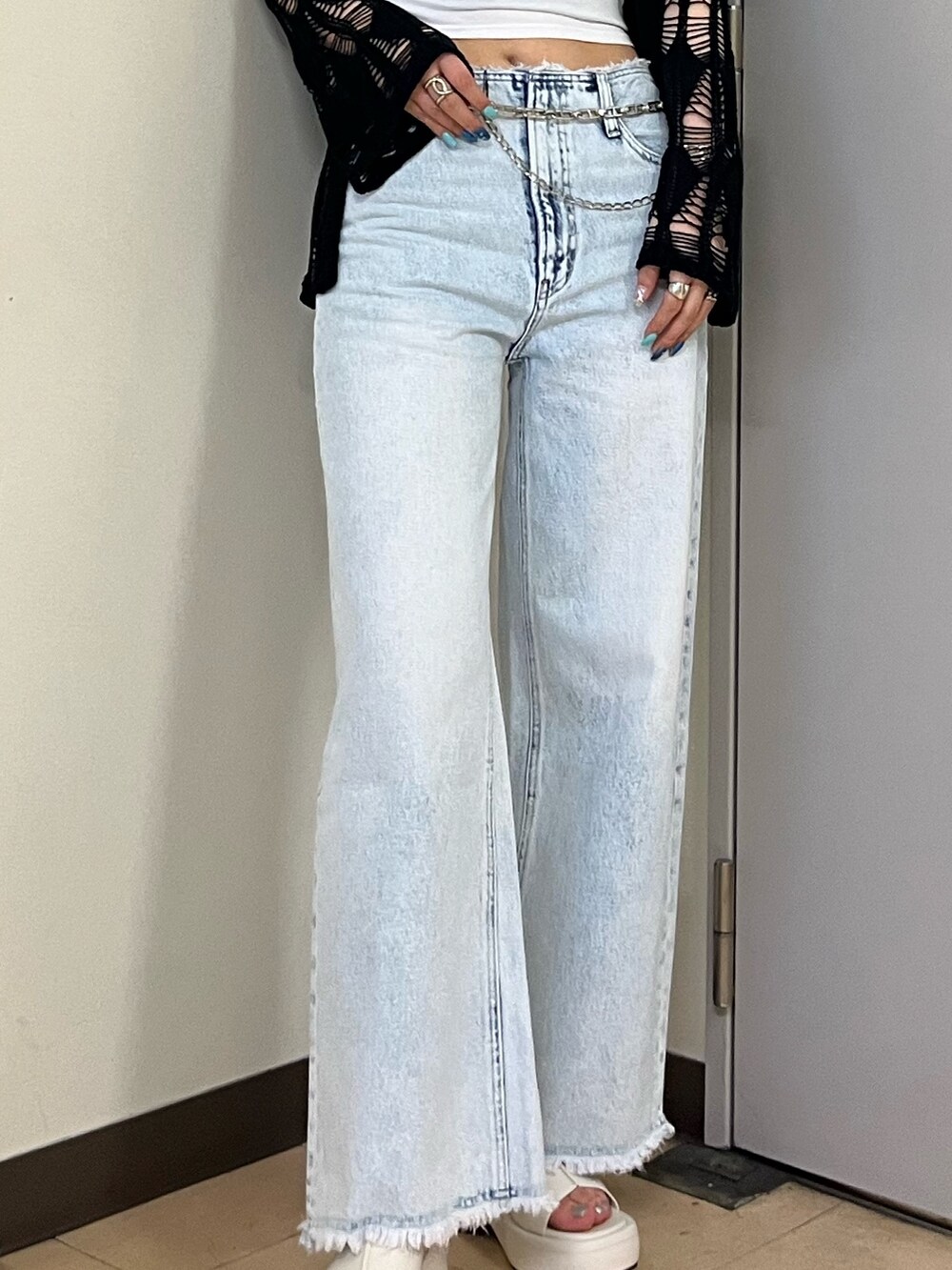 ホワイト系のキャミソール、ブルー系のデニムパンツ、ブラック系のカーディガン/ボレロを着用したレディースの春コーディネートの4枚目の写真