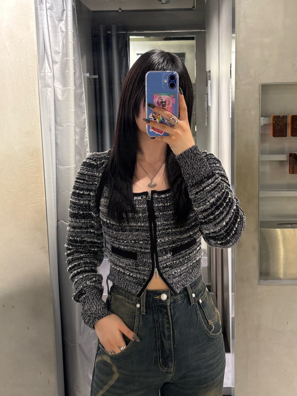 ブラック系のニット/セーター、ブルー系のデニムパンツ、ブラック系のブーツを着用したレディースの冬コーディネートの4枚目の写真