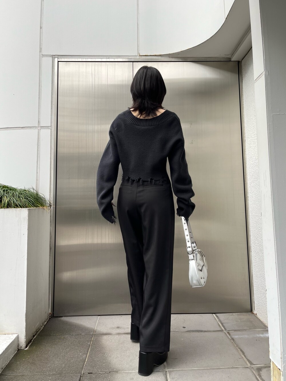 ブラック系のニット/セーター、ブラック系のブーツ、ブラック系のその他パンツを着用したレディースの冬コーディネートの3枚目の写真