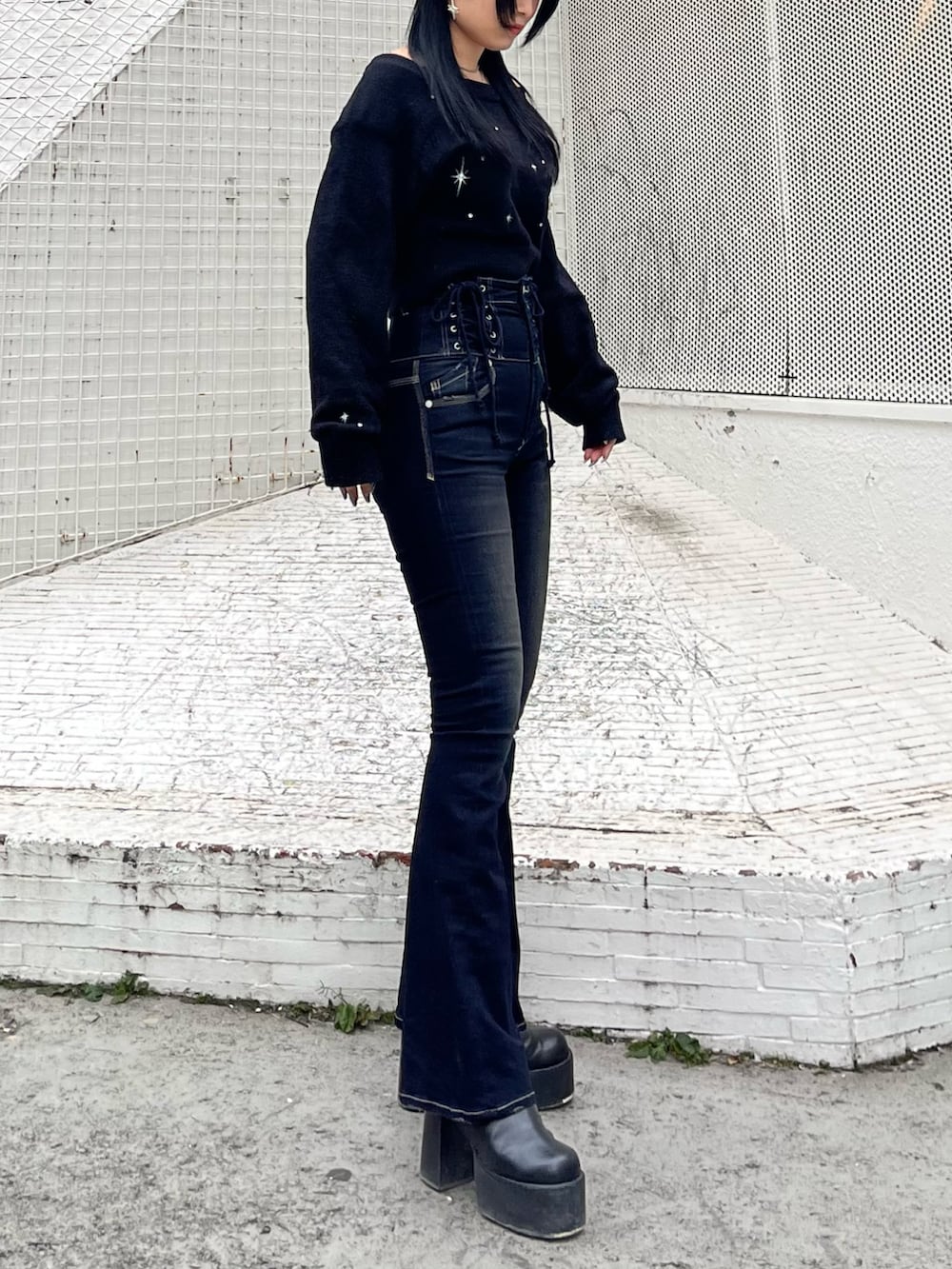 ブラック系のニット/セーター、ブルー系のデニムパンツ、ブラック系のブーツを着用したレディースの冬コーディネートの2枚目の写真