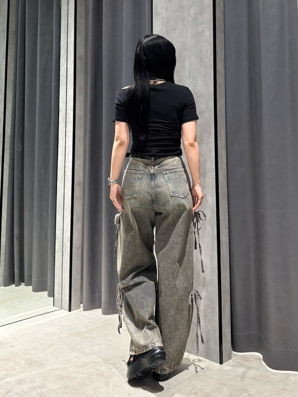 ブラック系のTシャツ/カットソー、ブルー系のデニムパンツ、ブラック系のサンダルを着用したレディースの春コーディネートの3枚目の写真