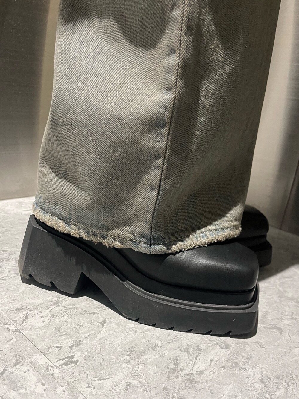 ブラック系のニット/セーター、グレー系のデニムパンツ、ブラック系のブーツを着用したレディースの冬コーディネートの7枚目の写真