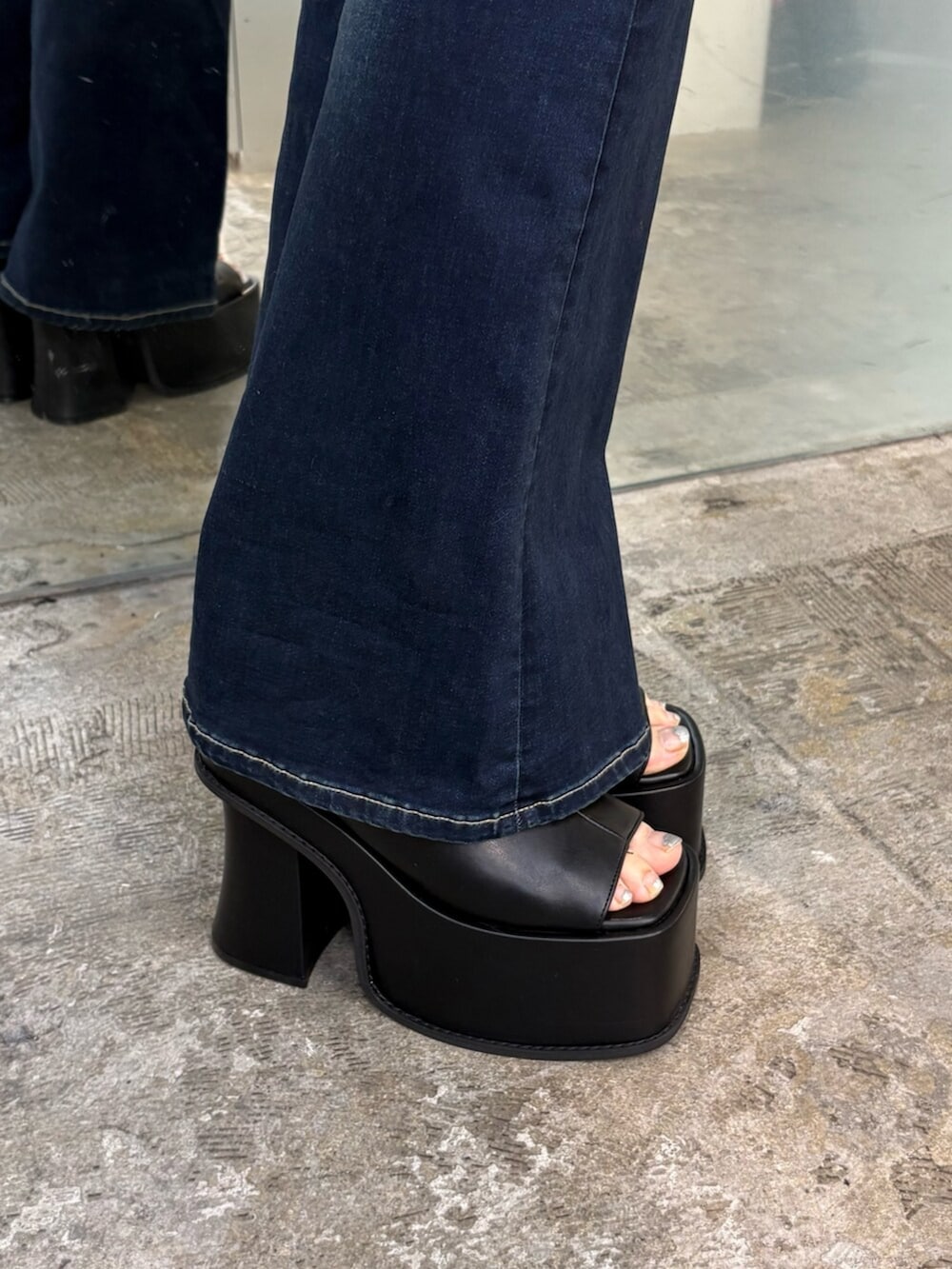 ブラック系のサンダル、ブルー系のデニムパンツ、ブラック系のニット/セーターを着用したレディースの夏コーディネートの6枚目の写真