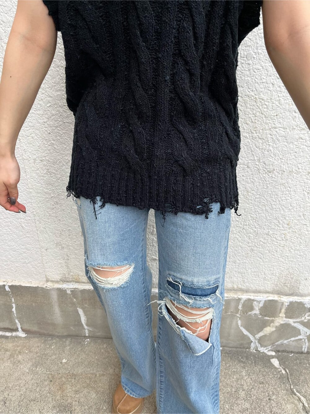 ブルー系のデニムパンツ、ベージュ系のスリッポン、ブラック系のベストを着用したレディースの秋コーディネートの6枚目の写真