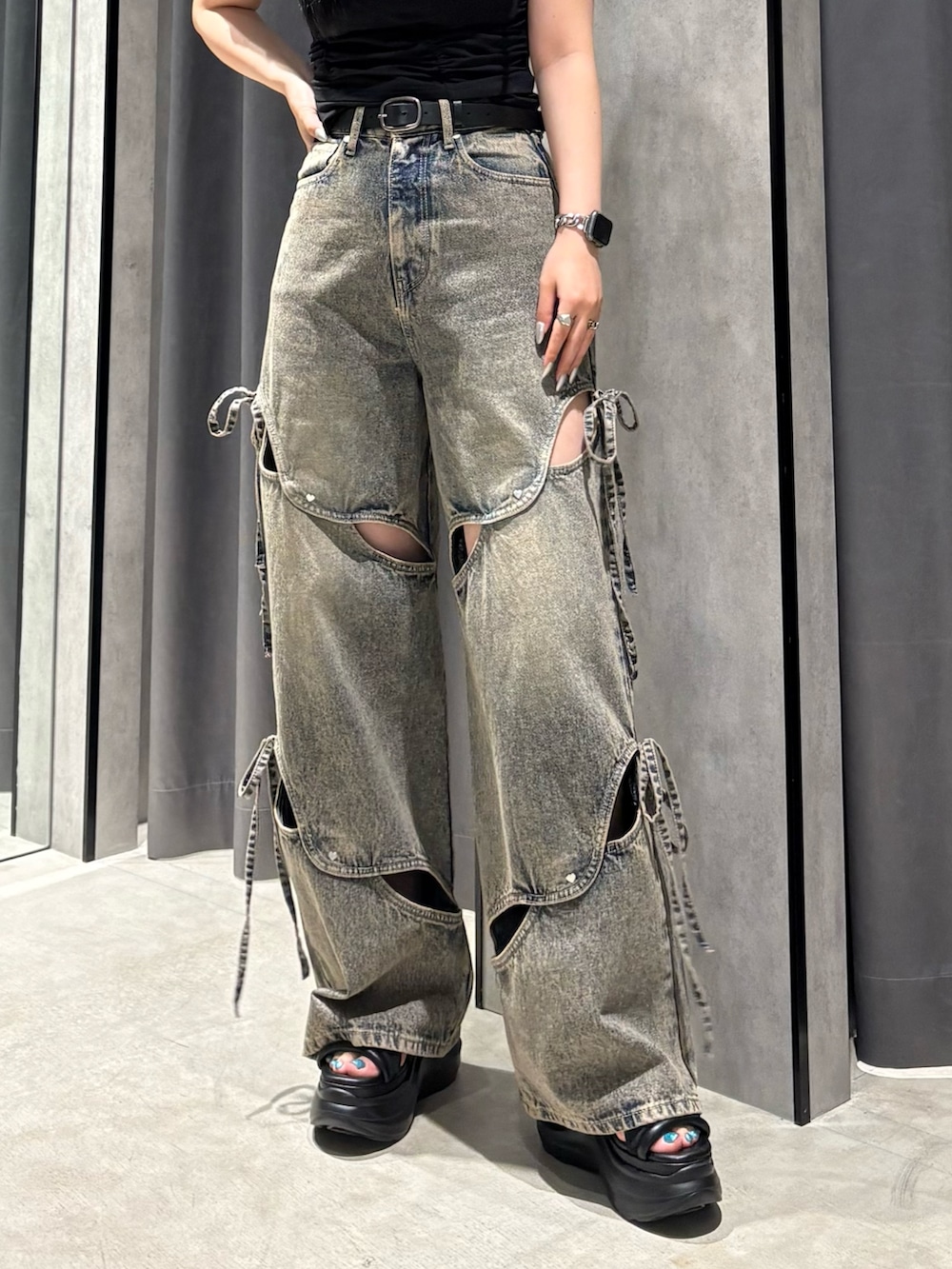 ブラック系のTシャツ/カットソー、ブルー系のデニムパンツ、ブラック系のサンダルを着用したレディースの春コーディネートの5枚目の写真