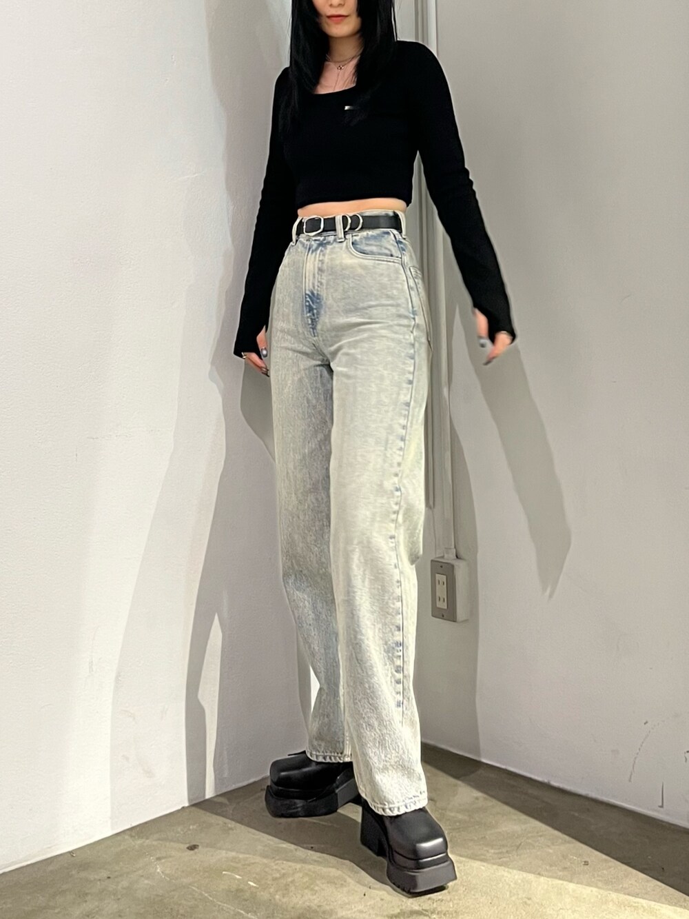 ブラック系のTシャツ/カットソー、ブラック系のブーツ、ブルー系のデニムパンツを着用したレディースの春コーディネートの2枚目の写真