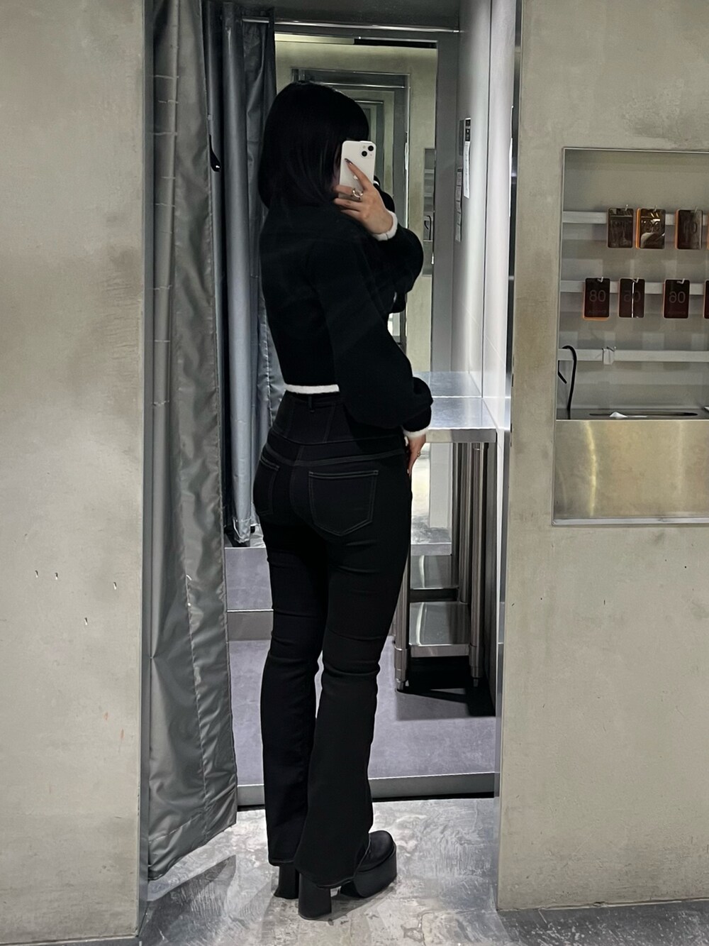 ブラック系のニット/セーター、ブラック系のデニムパンツ、ブラック系のブーツを着用したレディースの冬コーディネートの3枚目の写真