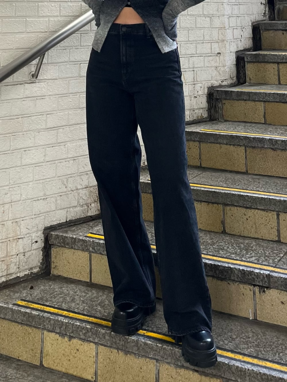 ブラック系のニット/セーター、ブラック系のデニムパンツ、ブラック系のブーツを着用したレディースの冬コーディネートの5枚目の写真