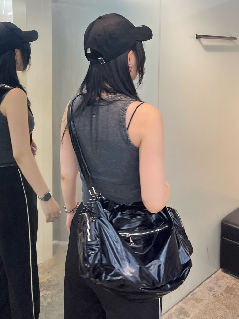 ブラック系のタンクトップ、ブラック系のハンドバッグ、ブラック系のスラックスを着用したレディースの夏コーディネートの5枚目の写真