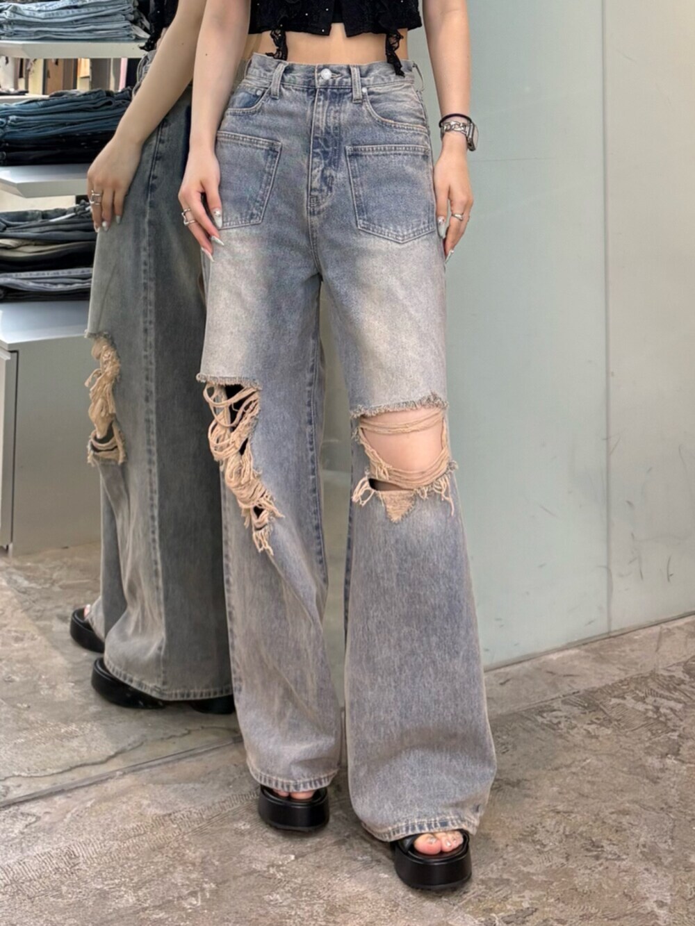ブルー系のデニムパンツ、ブラック系のTシャツ/カットソー、ブラック系のサンダルを着用したレディースの夏コーディネートの5枚目の写真