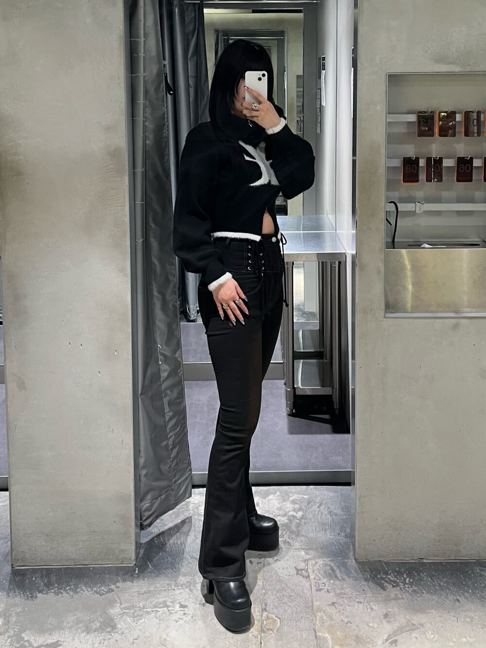 ブラック系のニット/セーター、ブラック系のデニムパンツ、ブラック系のブーツを着用したレディースの冬コーディネートの2枚目の写真