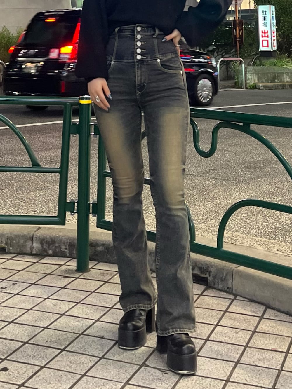 ブラック系のニット/セーター、ブルー系のデニムパンツ、ブラック系のブーツを着用したレディースの秋コーディネートの6枚目の写真