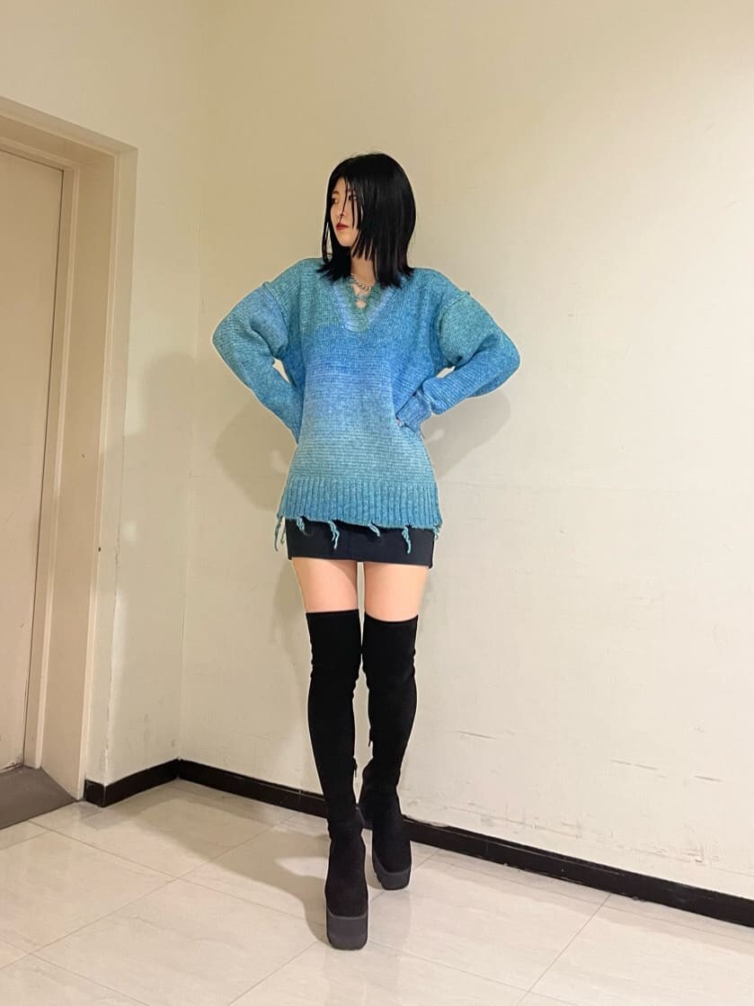 ブラック系のスカート、ブラック系のブーツ、ブラック系のスカートを着用したレディースの秋コーディネートの2枚目の写真