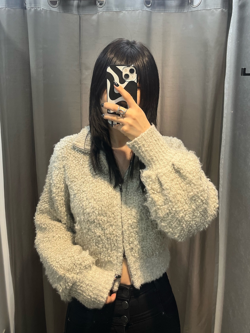 グレー系のニット/セーター、ブラック系のデニムパンツ、ブラック系のブーツを着用したレディースの秋コーディネートの3枚目の写真