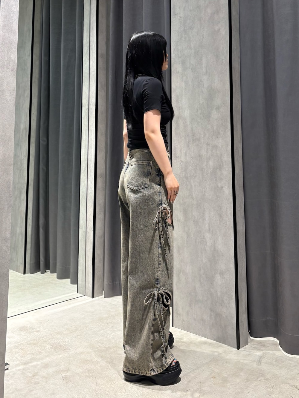 ブラック系のTシャツ/カットソー、ブルー系のデニムパンツ、ブラック系のサンダルを着用したレディースの春コーディネートの2枚目の写真