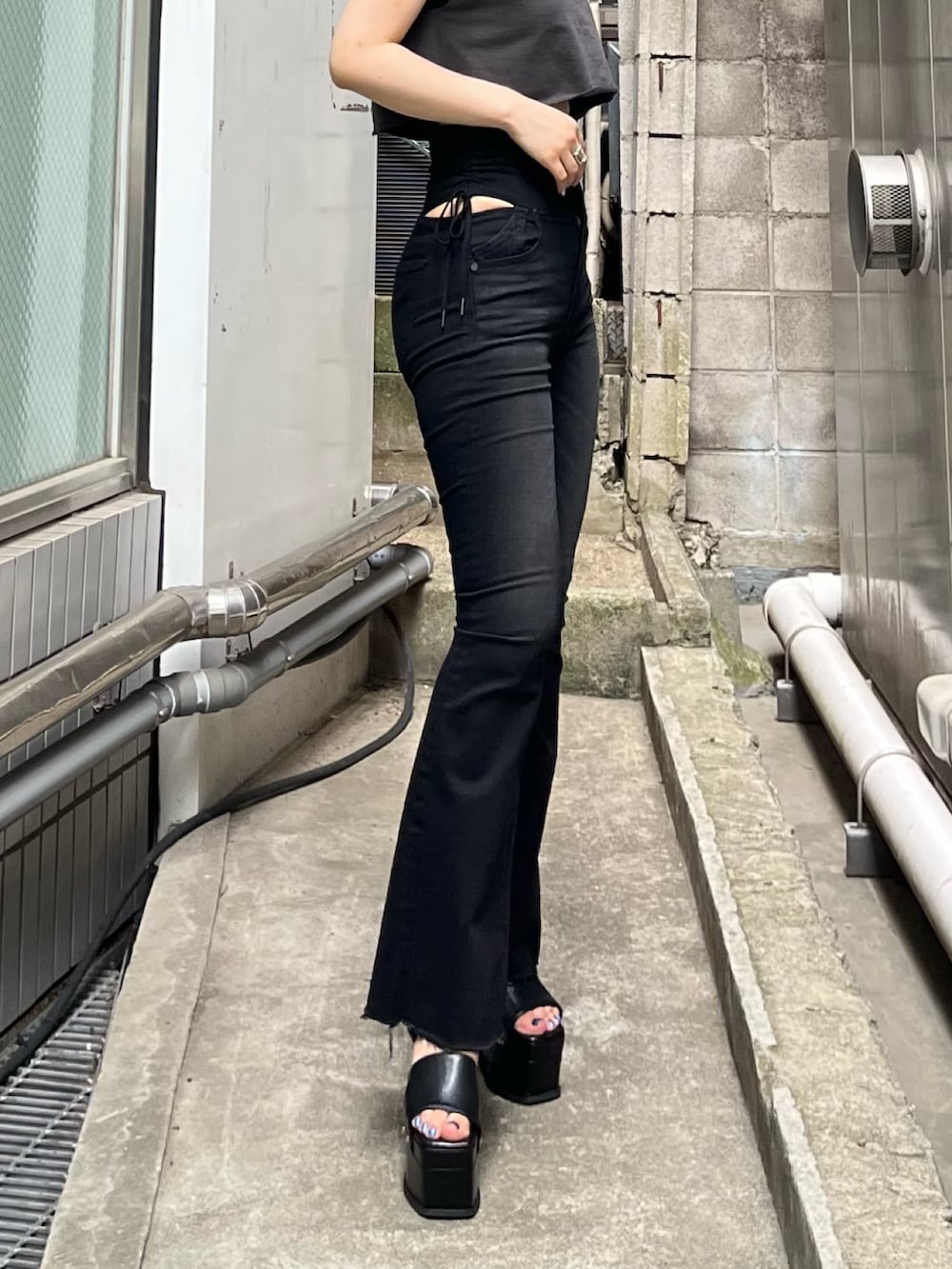 グレー系のTシャツ/カットソー、ブラック系のデニムパンツ、ブラック系のサンダルを着用したレディースの夏コーディネートの5枚目の写真