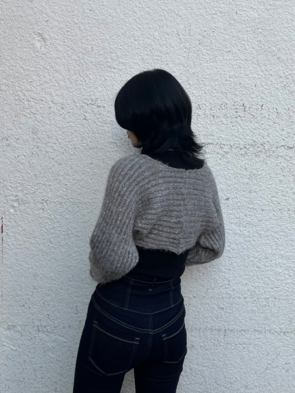 ブラック系のニット/セーター、ブルー系のデニムパンツ、ブラック系のローファーを着用したレディースの秋コーディネートの6枚目の写真