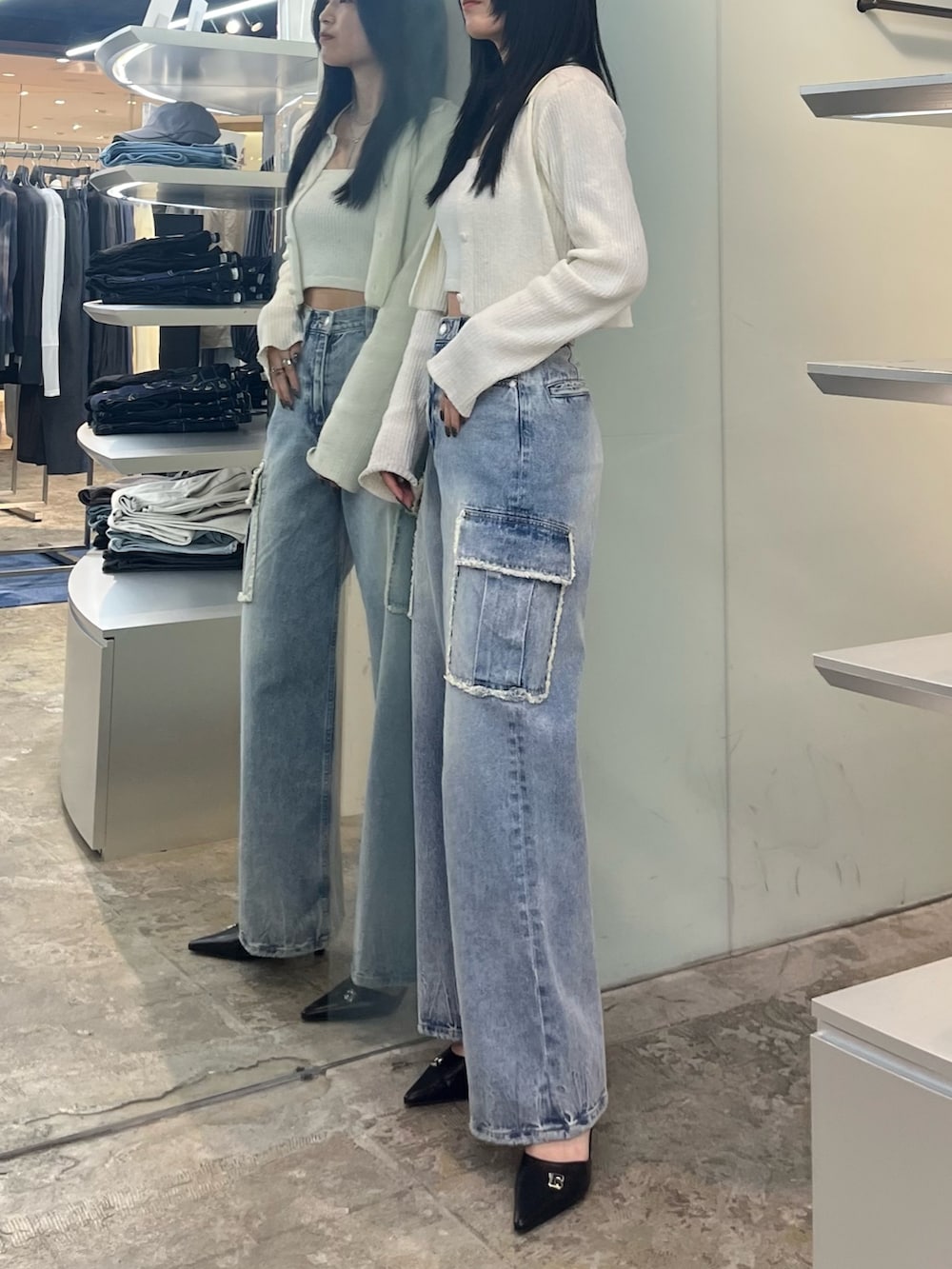 ホワイト系のニット/セーター、ブルー系のデニムパンツ、ブラック系のパンプスを着用したレディースの春コーディネートの3枚目の写真