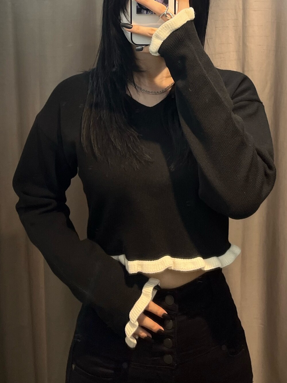 ブラック系のニット/セーター、ブラック系のデニムパンツ、ブラック系のブーツを着用したレディースの冬コーディネートの4枚目の写真