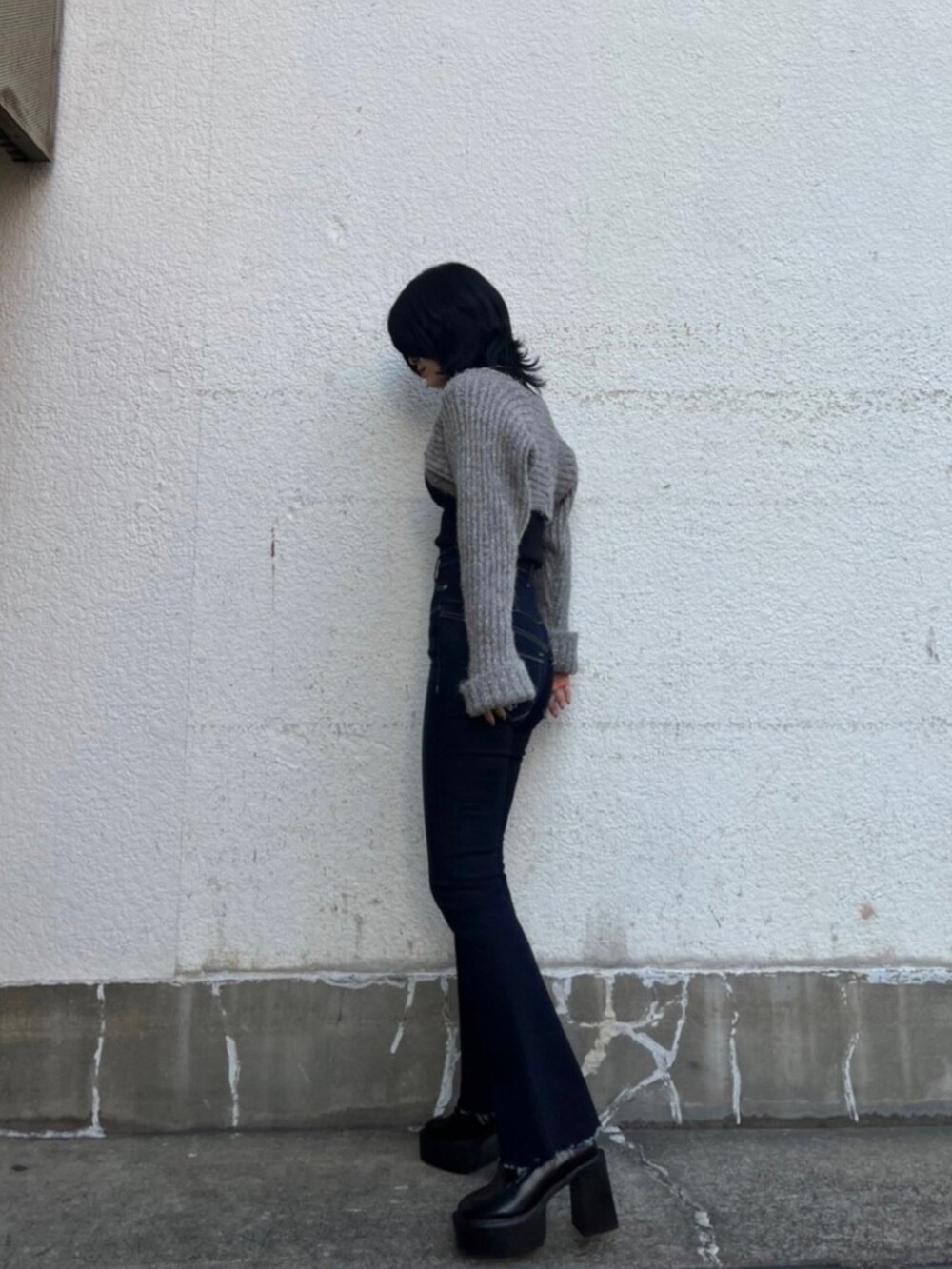 ブラック系のニット/セーター、ブルー系のデニムパンツ、ブラック系のローファーを着用したレディースの秋コーディネートの4枚目の写真