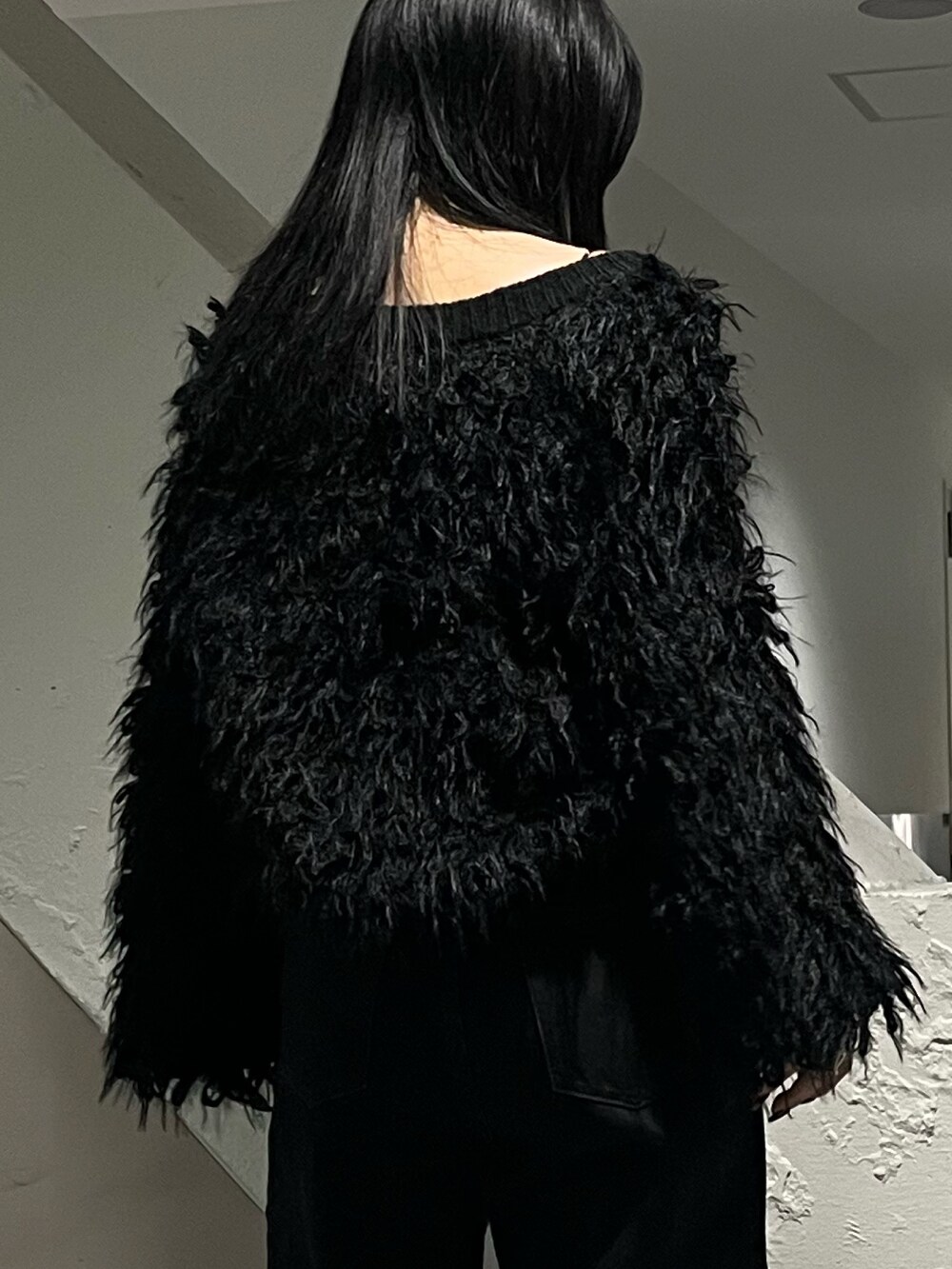 ブラック系のカーディガン/ボレロ、ブラック系のデニムパンツ、ブラック系のブーツを着用したレディースの秋コーディネートの6枚目の写真