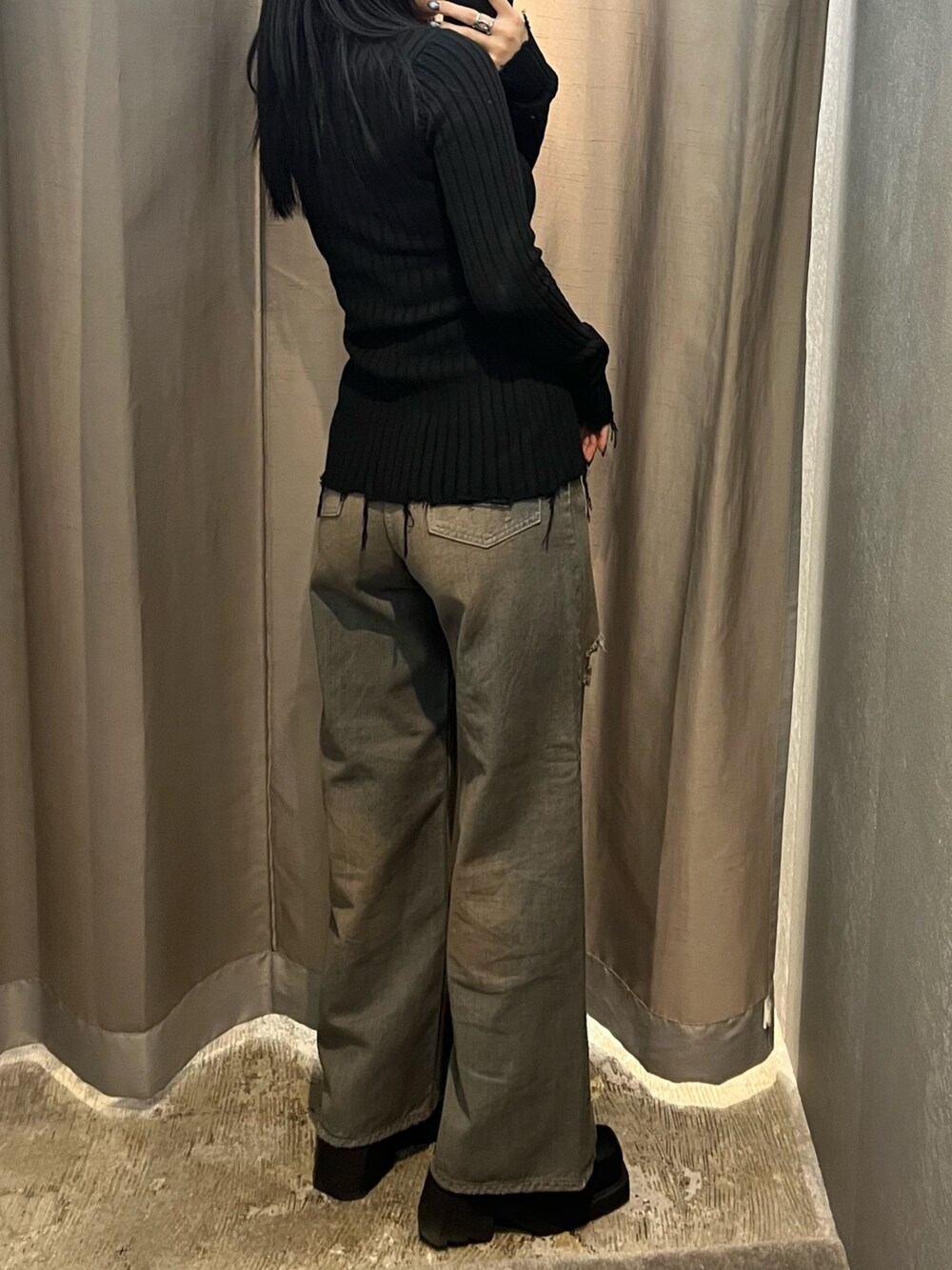 ブラック系のニット/セーター、グレー系のデニムパンツ、ブラック系のブーツを着用したレディースの冬コーディネートの4枚目の写真