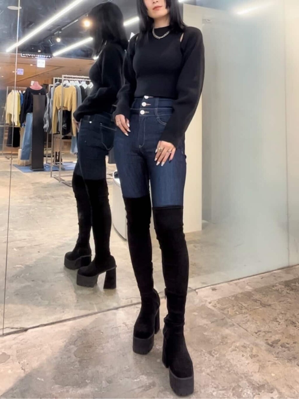 ブルー系のデニムパンツ、ブルー系のデニムパンツ、ブラック系のブーツを着用したレディースの秋コーディネートの3枚目の写真