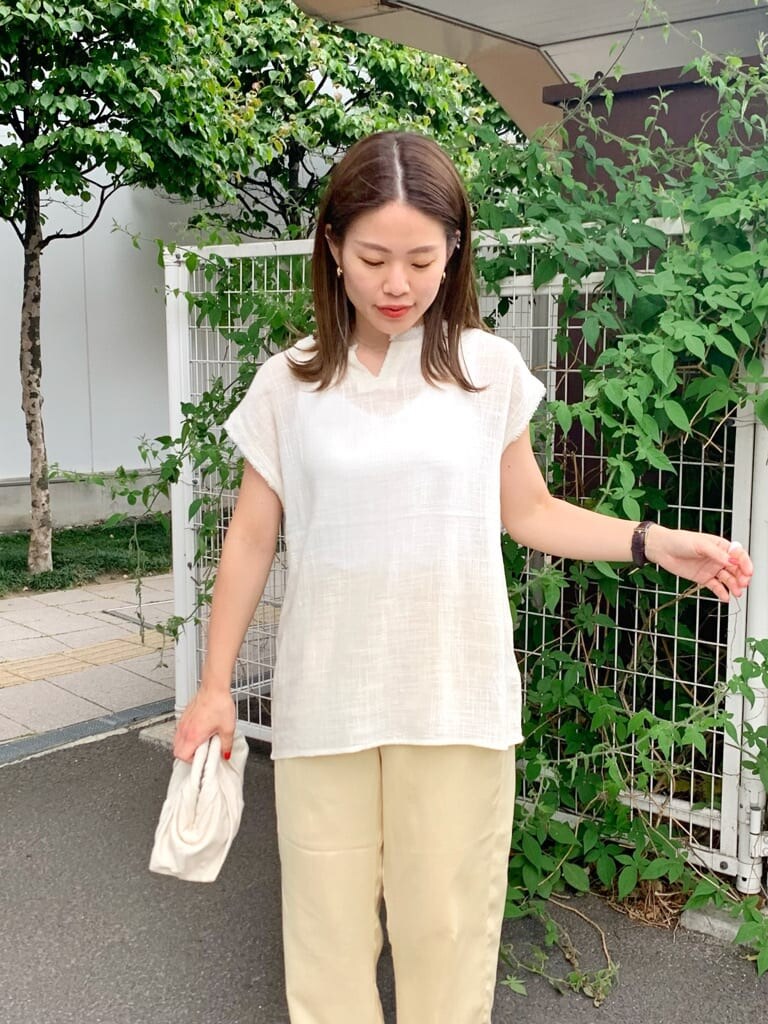 ホワイト系のクラッチバッグ、ホワイト系のシャツ/ブラウス、ブラウン系のサンダルを着用したレディースの夏コーディネートの4枚目の写真