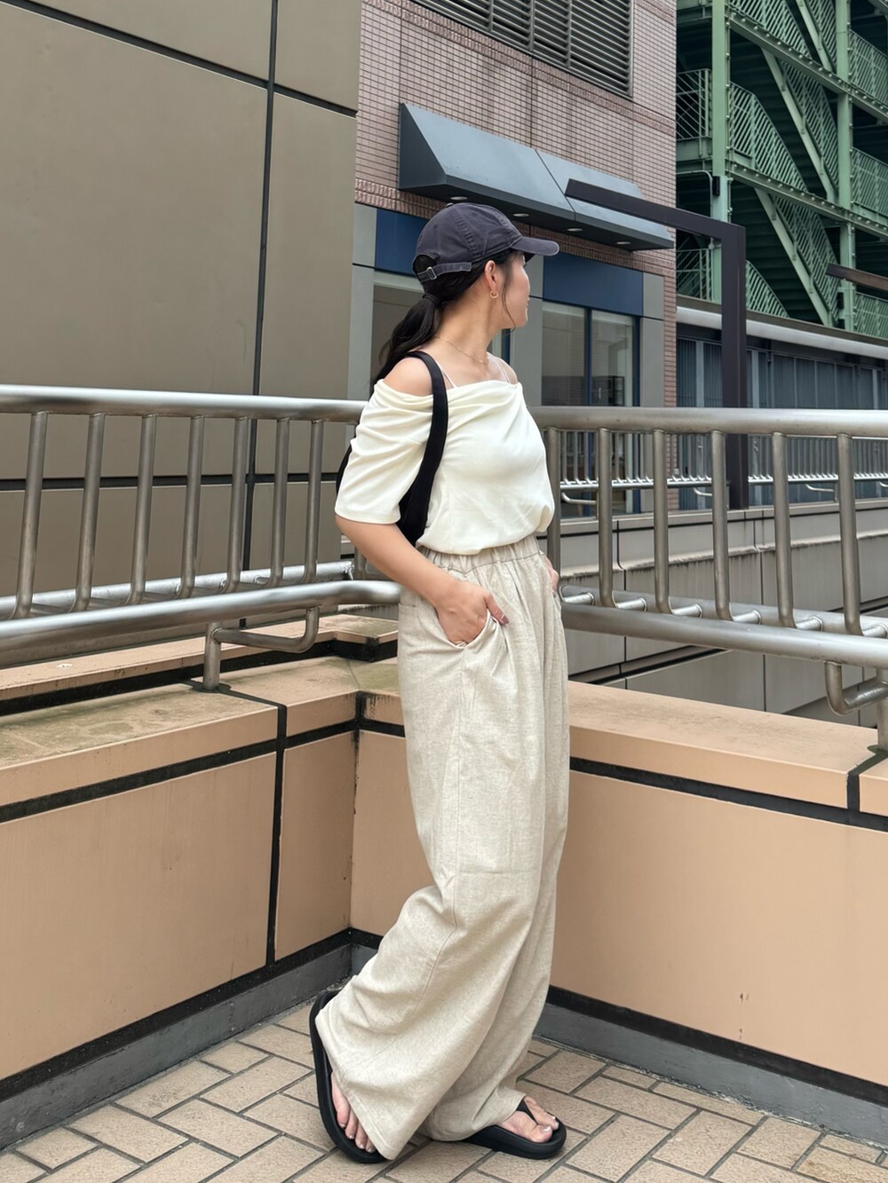 ホワイト系のTシャツ/カットソー、ベージュ系のその他パンツ、ブラック系のハンドバッグを着用したレディースの夏コーディネートの3枚目の写真