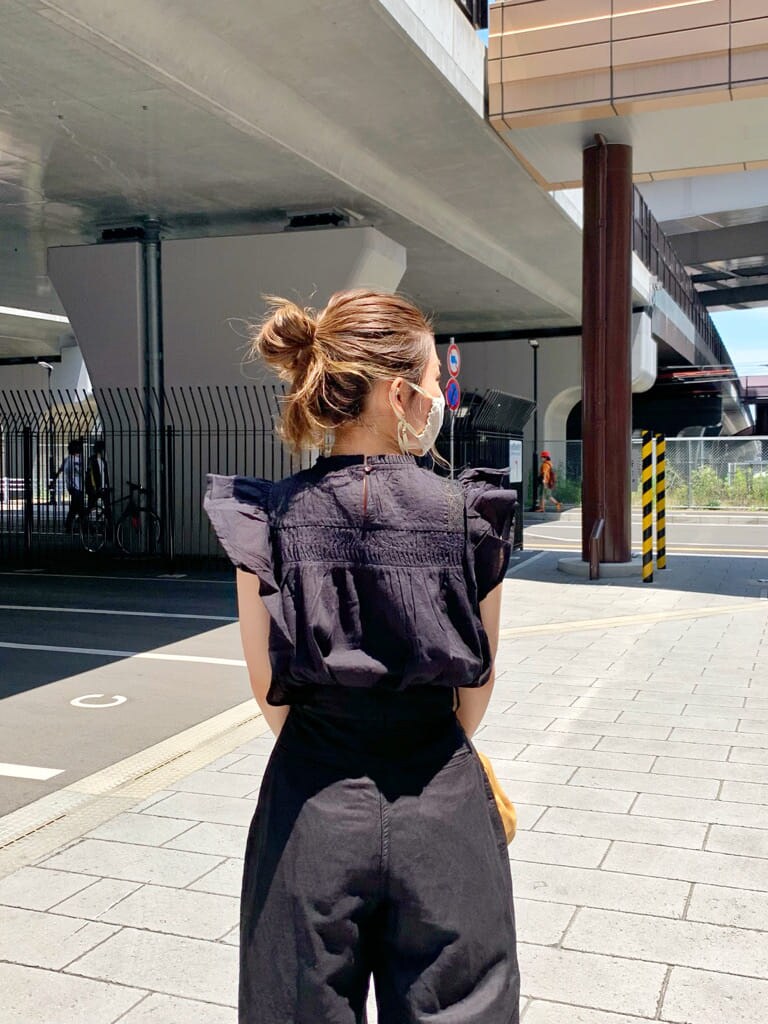 ブラック系のその他パンツ、ベージュ系のクラッチバッグ、ブラウン系のサンダルを着用したレディースの夏コーディネートの4枚目の写真