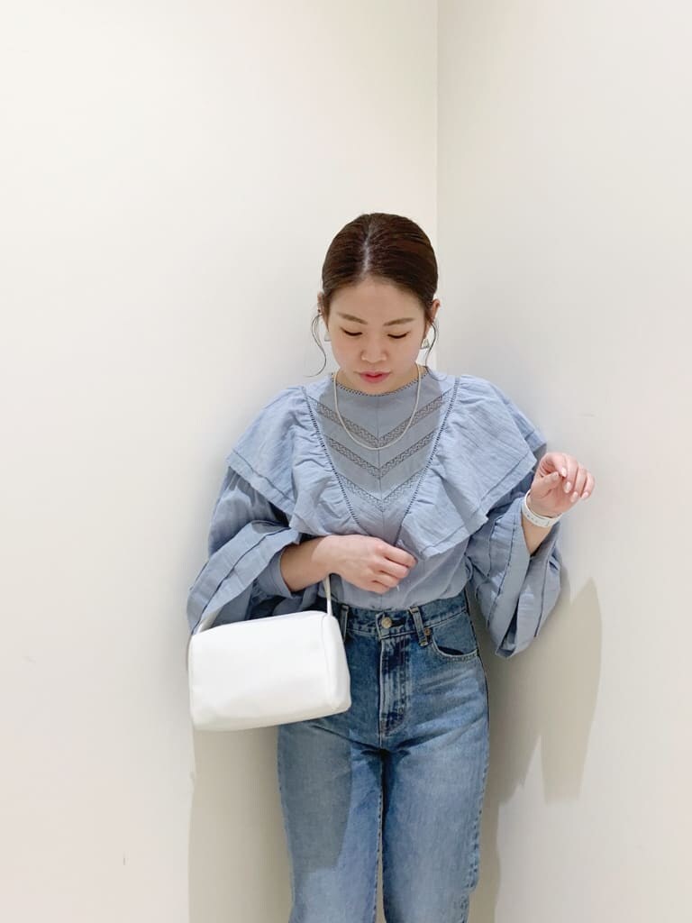 ブルー系のデニムパンツ、ブルー系のシャツ/ブラウス、ホワイト系のハンドバッグを着用したレディースの冬コーディネートの3枚目の写真