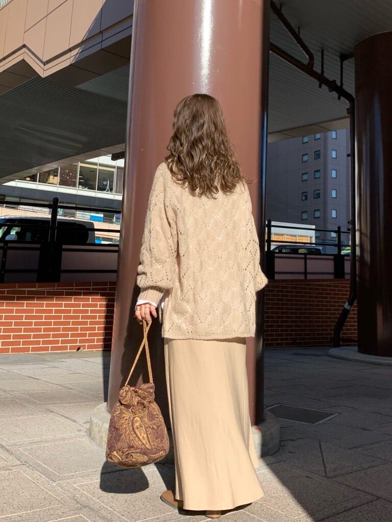 ブラウン系のハンドバッグ、ベージュ系のスカート、ベージュ系のニット/セーターを着用したレディースの秋コーディネートの5枚目の写真