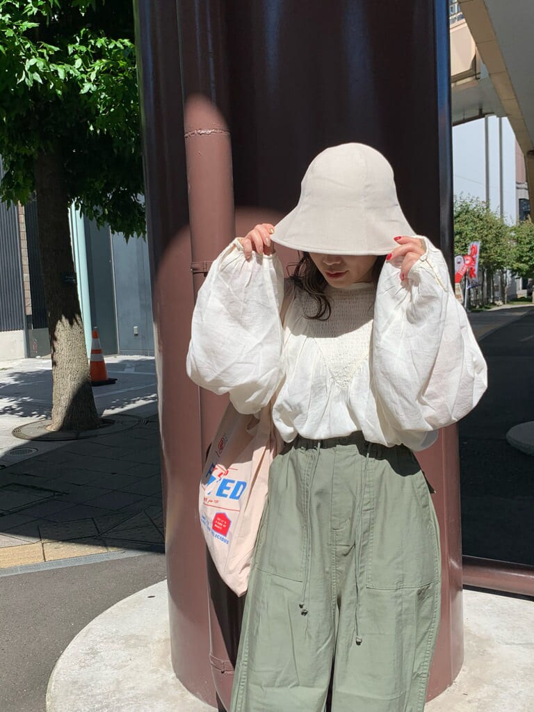 ベージュ系のその他パンツ、ホワイト系のシャツ/ブラウス、ベージュ系のエコバッグ/サブバッグを着用したレディースの夏コーディネートの4枚目の写真