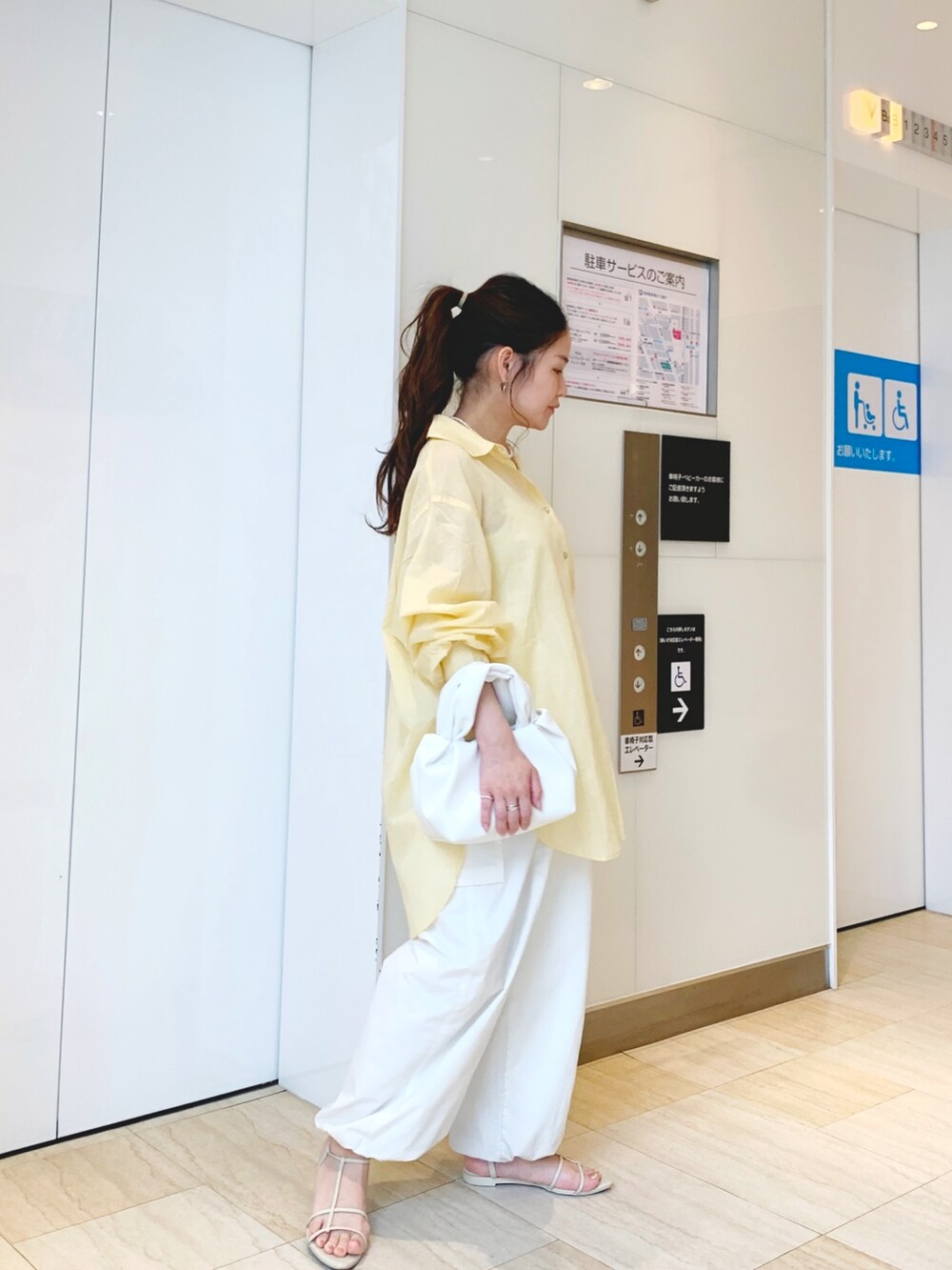 イエロー系のシャツ/ブラウス、ホワイト系のカーゴパンツ、ホワイト系のハンドバッグを着用したレディースの春コーディネートの2枚目の写真