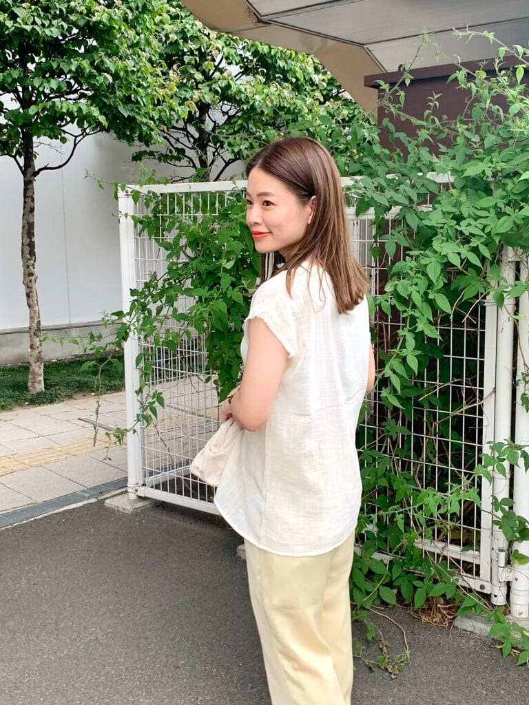 ホワイト系のクラッチバッグ、ホワイト系のシャツ/ブラウス、ブラウン系のサンダルを着用したレディースの夏コーディネートの5枚目の写真